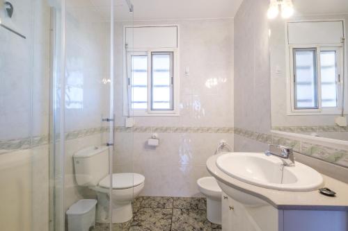 une salle de bains blanche avec toilettes et lavabo dans l'établissement El Refugi, à Vinaròs