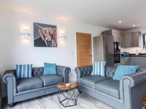 a living room with two couches and a table at Strawberry Bank - Nuthatch in Holsworthy
