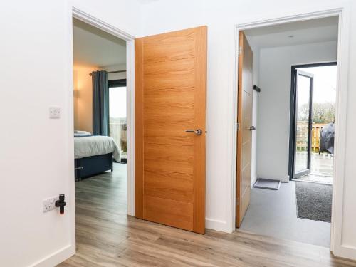 a room with a door leading to a bedroom at Strawberry Bank - Nuthatch in Holsworthy