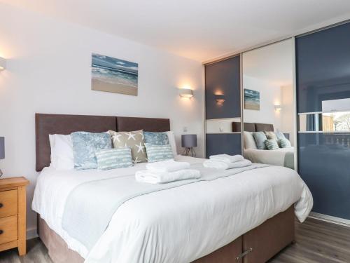 a bedroom with a large bed with towels on it at Strawberry Bank - Nuthatch in Holsworthy