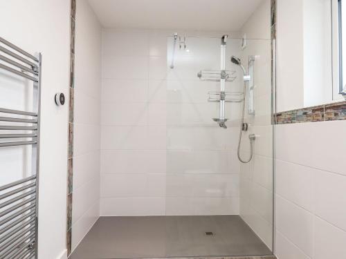 a white bathroom with a shower with a glass door at Strawberry Bank - Nuthatch in Holsworthy