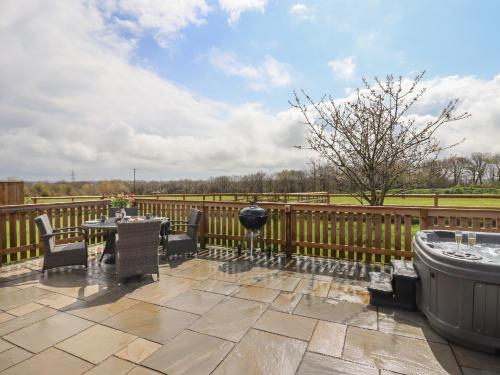a patio with a fence and a hot tub at Strawberry Bank - Nuthatch in Holsworthy