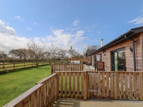 a house with a wooden deck next to a yard at Strawberry Bank - Nuthatch in Holsworthy