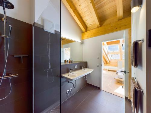 uma casa de banho com um lavatório e um chuveiro em Gipfelkreuz mit Sauna em Garmisch-Partenkirchen