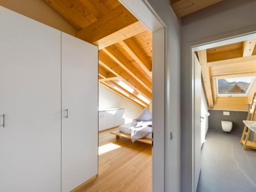 um quarto no sótão com uma cama e uma porta que leva a um quarto em Gipfelkreuz mit Sauna em Garmisch-Partenkirchen
