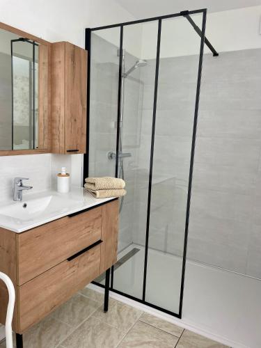 une salle de bain avec une douche en verre et un lavabo dans l'établissement Chambres d'Hôtes Lefoulon, à Pirou