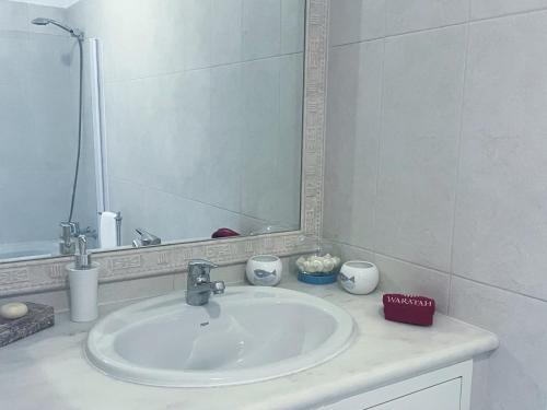 y baño con lavabo y espejo. en Beautiful apartment set in the heart of Quinta en Almancil