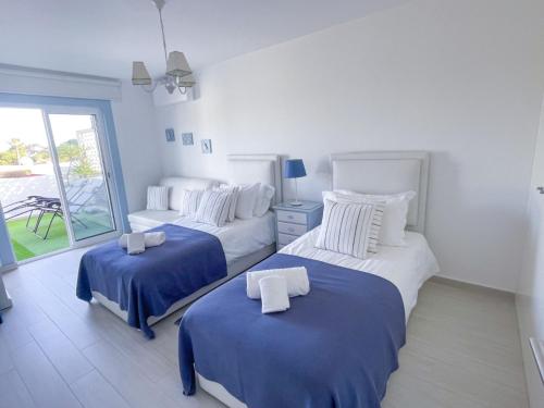 1 dormitorio con 2 camas con sábanas azules y blancas en Beautiful apartment set in the heart of Quinta, en Almancil