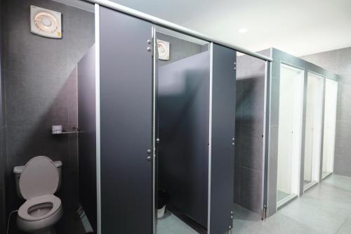 a bathroom with a toilet and a glass stall at Wayha Hostel Don Mueang Airport in Bangkok