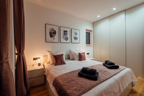 a bedroom with a bed with two black towels on it at Villa Vitrenik, Cista Velika, Makarska-Imotski in Velika Cista
