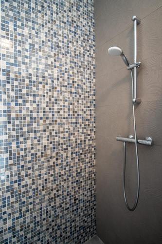 a shower in a bathroom with a tiled wall at HY 2 SIBIU in Şelimbăr