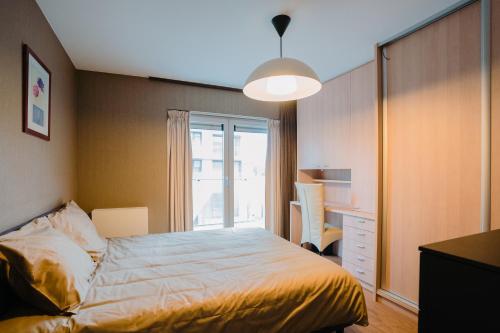 a bedroom with a bed and a desk and a window at Icons 2 in Ostend