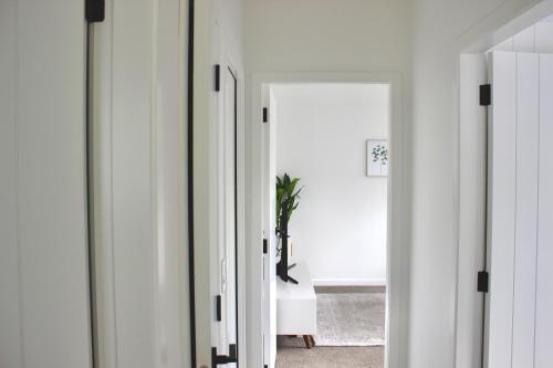 a hallway with white walls and a mirror at Zen hideaway in Aotea in Porirua