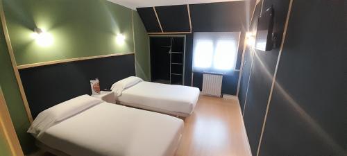 a small room with two beds and a window at HMC K-ena in Andorra la Vella