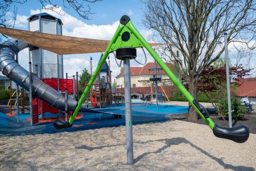 a playground with a slide in a park at Kolping Family Resort in Hévíz