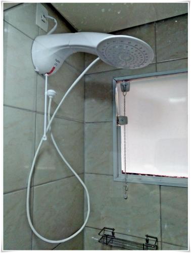 a shower with a white shower head in a bathroom at Pousada Seu Jorge in Campinas