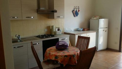 uma cozinha com uma mesa e cadeiras e um frigorífico em Casa vista mare golfo di Budoni em Budoni
