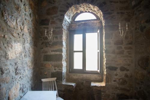 a window in a stone room with a table and a chair at Lida Mary in Mestá