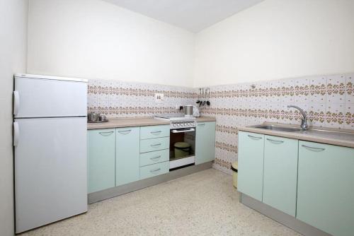 uma cozinha com armários azuis e um frigorífico branco em Standard 1 bedroom Balluta Bay (5) em Sliema