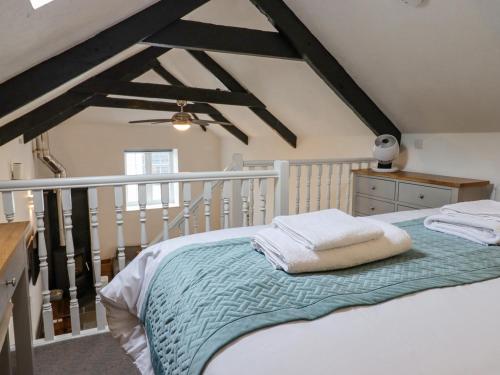 a bedroom with a bed with a green blanket at Strawberry Bank - Pipistrelle in Holsworthy