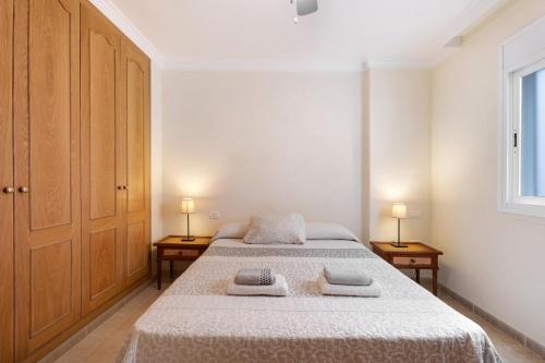 um quarto com uma cama e duas lâmpadas em duas mesas em Las Brisas Playa San Juan By Paramount Holidays em Guía de Isora