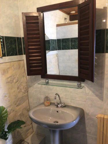 Le gîte de Gascogne في ليكتور: حمام مع حوض ومرآة