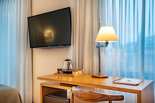 a hotel room with a desk with a television and a lamp at Gran Hotel Victoria in Santander