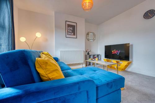 un divano blu in soggiorno con TV di Buckwell Heights - 2 Bedroom Free Parking Wifi Sky TV a Wellingborough