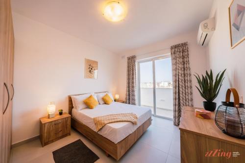 a bedroom with a bed and a large window at Modern Apartments in Malta's charming Mosta in Mosta