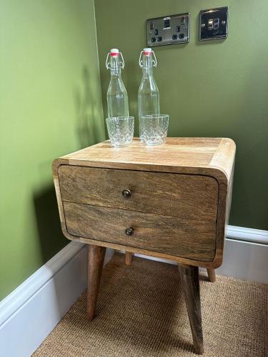 two glass bottles sitting on top of a wooden table at Rooms Above Sugar Boat in Helensburgh
