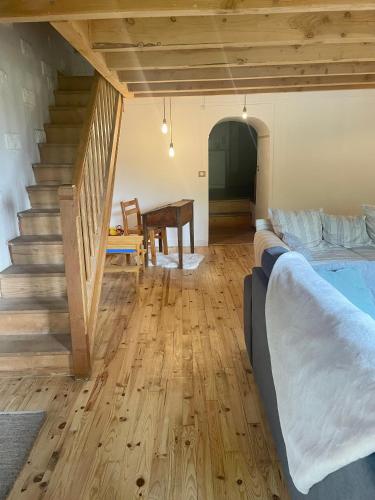 Cette chambre comprend un lit, une table et des escaliers. dans l'établissement La maison de Cabannes, à Moulin-Mage