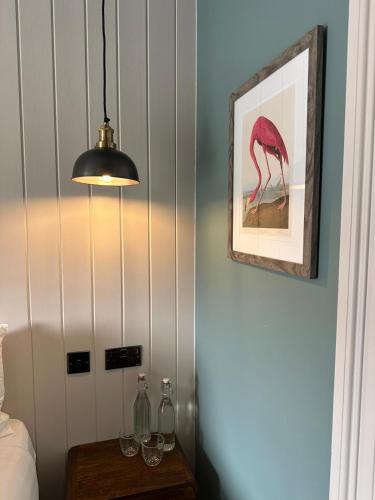 a room with a table with a picture of a flamingo at Rooms Above Sugar Boat in Helensburgh