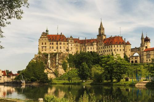 a large castle on top of a hill next to a river at Ferienhaus zur Donau in Herbertingen