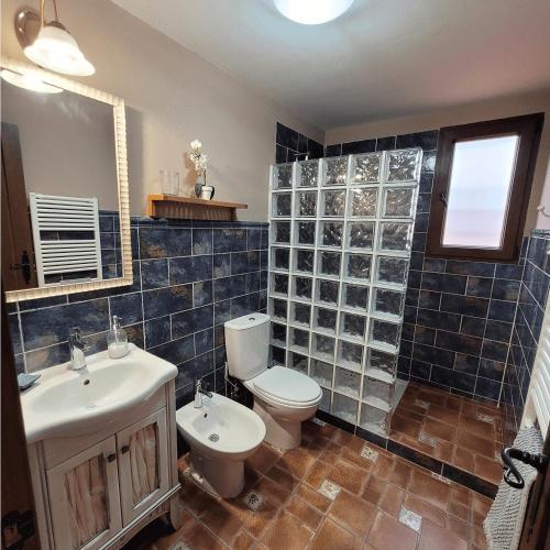 bagno con servizi igienici, lavandino e specchio di LA CANTERICA a Fuentes de Rubielos