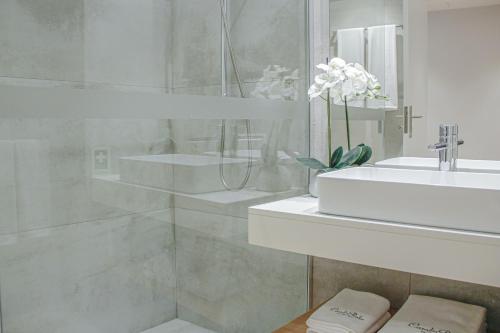 a white bathroom with a sink and a shower at Casal da Penha Apartments in Funchal