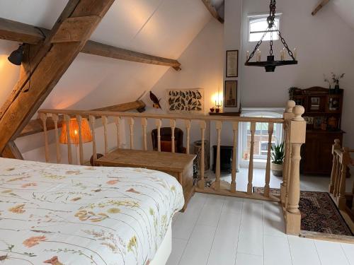 an attic bedroom with a bed and a table at Luxe appartement Droom in de polder -DE SALON- met prive-sauna in Arnemuiden