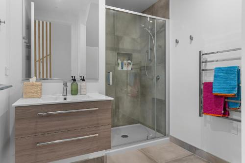 La salle de bains est pourvue d'une douche et d'un lavabo. dans l'établissement Coastal Cool - Luxury Langs Beach Accommodation, à Langs Beach
