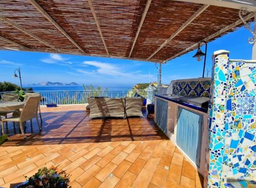 un patio con tavolo, sedie e vista sull'oceano di Maridea - Magia di Circe a Ponza