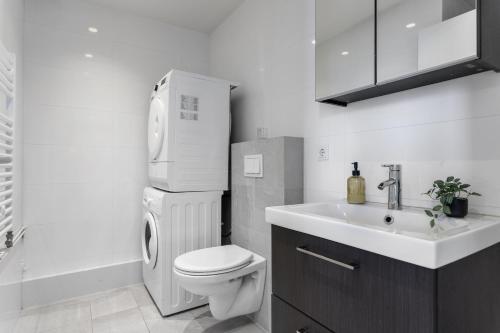 a white bathroom with a toilet and a sink at GreenKey Apartment V13 in Reykjavík