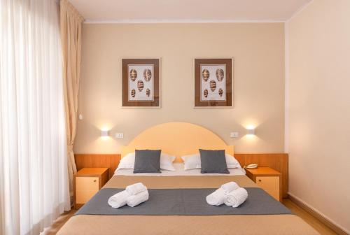 Hotel Stella D'Italia في فياريجيو: غرفة نوم عليها سرير وفوط