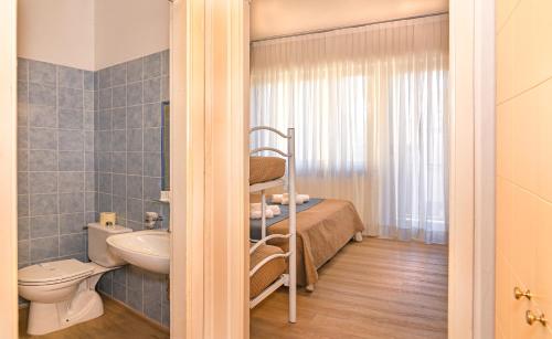 a small bathroom with a bed and a toilet at Hotel Stella D'Italia in Viareggio