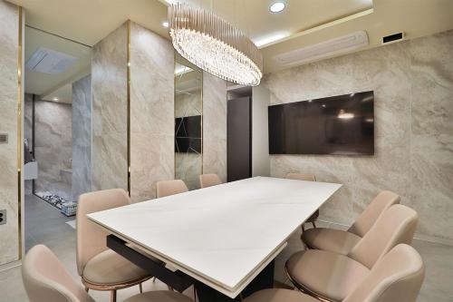 a dining room with a white table and chairs at Ytt Hotel in Busan