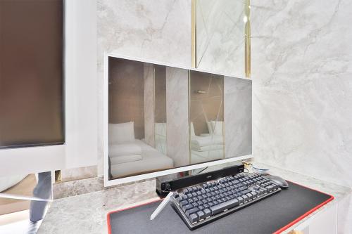 a computer monitor and a keyboard on a desk at Ytt Hotel in Busan