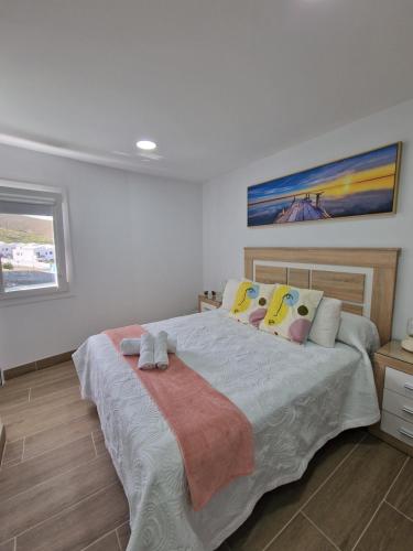 ein Schlafzimmer mit einem großen Bett mit Kissen darauf in der Unterkunft Alojamiento Agaete Pueblo Nº7 in Agaete