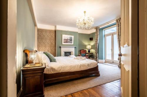 a bedroom with a large bed and a chandelier at Pass the Keys Williams Nest Period Dartmoor Apartment in stunning town setting in Newton Abbot