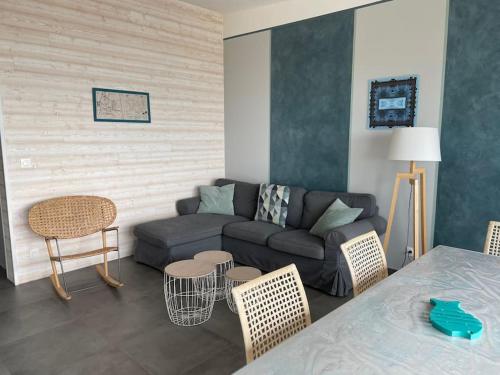 - un salon avec un canapé, une table et des chaises dans l'établissement Superbe maison face mer à Pirou, à Pirou