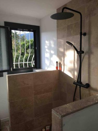 La salle de bains est pourvue d'une douche et d'une fenêtre. dans l'établissement Villa climatisée, vue mer et colline avec piscine, aux Issambres