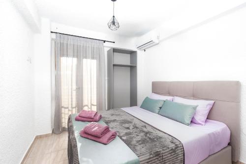 a bedroom with a bed with pink and blue pillows at Villa Alex Holiday Home in Kriopigi