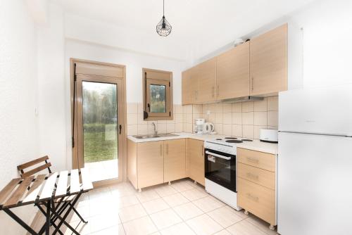 a kitchen with white appliances and a table and chairs at Villa Alex Holiday Home in Kriopigi