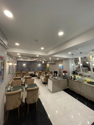 Un comedor con mesas y sillas en un restaurante. en GRAND HAMİT By Karadayı Airport Hotel, en Arnavutköy